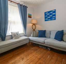 A living room with a sofa and lamp at Driftmark in Weymouth