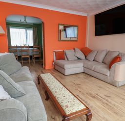 A living room with a sofa and coffee table at Hafan Deg in Holywell