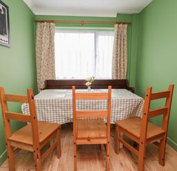 A dining room with a table and wooden chairs at Hafan Deg in Holywell