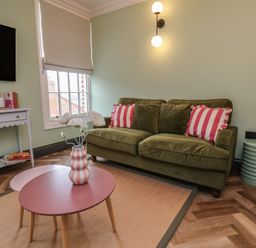 A living room with a green sofa and a coffee table at Apartment Green in Whitby