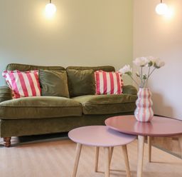 A living room with a green sofa and coffee table at Apartment Green in Whitby