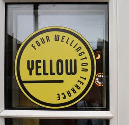 A yellow sign stating FOUR WELLINGTON TERRACE at Apartment Yellow in Whitby