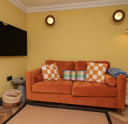 A living room with a sofa and television at Apartment Yellow in Whitby
