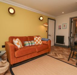 A living room with a sofa and table at Apartment Yellow in Whitby