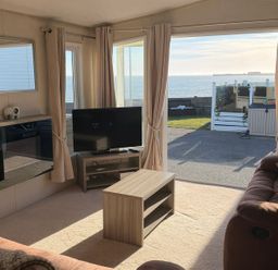 A living room with a TV and a coffee table at Trecco Bay holiday park, Porthcawl