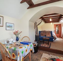 A living room with a sofa and a dining table at Moorland Retreat in Bodmin