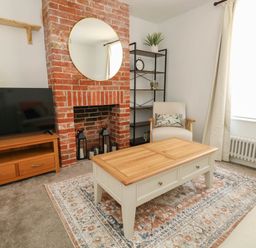 A living room with a coffee table and a television at The Watch House in Weymouth