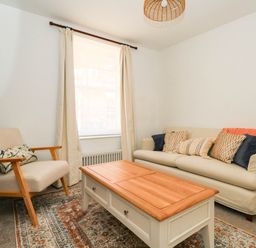 A living room with a sofa and an armchair at The Watch House in Weymouth
