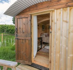 A hut entrance with furniture and grass at The Little Shepherds Hut with a View Builth Wells