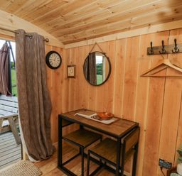 An indoor photo of a room with a wooden table and chairs at The Little Shepherds Hut with a View in Builth Wells