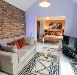 A living room with a sofa and television at Smithy Cottage in Cemaes Bay