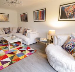 A living room with a sofa and table at Gwelfor in Cemaes Bay