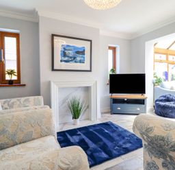 A living room with a sofa and television at Trefin in Cemaes Bay