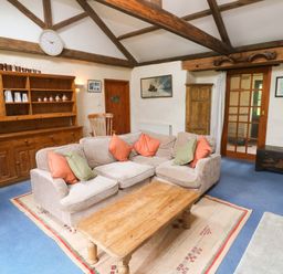 A living room with a sofa and coffee table at Swallow Cottage in Helston