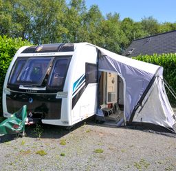 A caravan with an awning and chairs at Caravan in Dolton