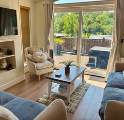 A living room with a television, sofa, and coffee table at Lakeside Retreat in Newton Abbot