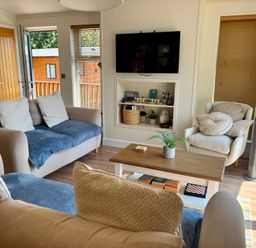A living room with a sofa and table at Lakeside Retreat in Newton Abbot