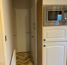 A kitchen with cabinets and a microwave at The Old Barn in Manchester