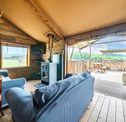 A living room with a sofa and wooden wall at Luxury Safari Lodge Sleeps 4/6 Deer Park Dogs Ok, Zeal Monachorum near Bow