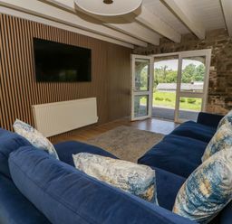 A living room with a sofa and television at The Cart House in Pontsian