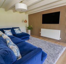 A living room with a sofa and television at The Cart House in Pontsian