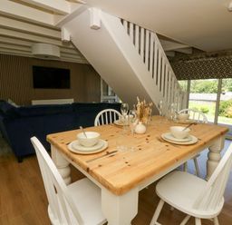 A dining room with a wooden table and chairs at The Cart House in Pontsian
