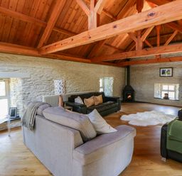 A living room with a sofa and television at Yr Hen Felin in Boncath
