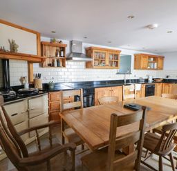 A kitchen with a dining table and chairs at Yr Hen Felin in Boncath