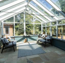 A conservatory with seating and windows at Yr Hen Felin in Boncath
