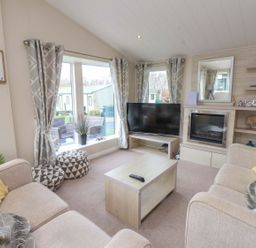 A living room with a television and coffee table at 56 The Stables Pwllheli