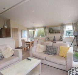 A living room with sofa and dining table at 56 The Stables in Pwllheli