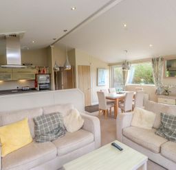 A living room with sofas and a dining area at 56 The Stables in Pwllheli
