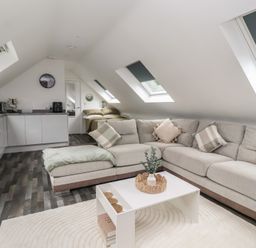 A living room with a sofa and kitchen area at Fields view in Bridlington