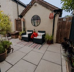 An outdoor seating area with a round mirror and planters at TyCosy in St Davids