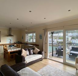 A living room with a dining area and kitchen at Rivercrest in Looe