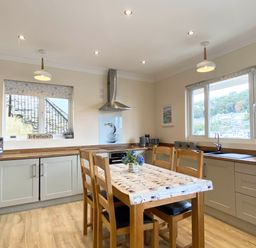 A kitchen with a table and chairs at Rivercrest in Looe