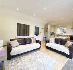 A living room with two sofas and a dining area at Rivercrest in Looe