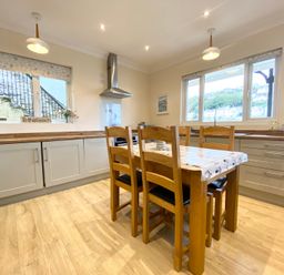 A kitchen with a wooden table and chairs at Rivercrest in Looe