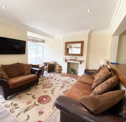 A living room with a sofa and armchairs at Nesden House 