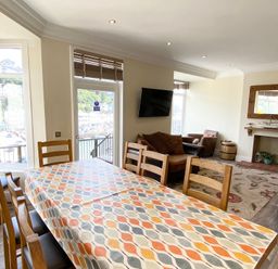 A dining room with a table and chairs at Nesden House 