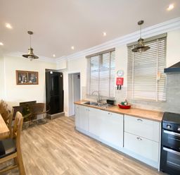 A kitchen with a refrigerator and sink at Nesden House 