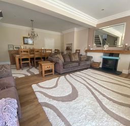 A living room with a dining area and furniture at Harbour Lodge in Looe