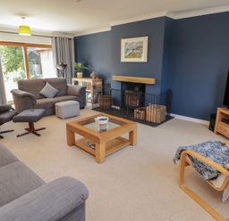 A living room with a sofa and chairs at Ty Traeth in Porthcawl