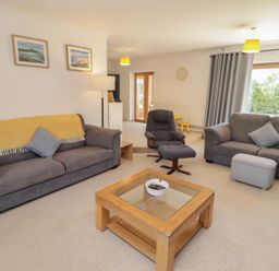 A living room with sofas and a coffee table at Ty Traeth in Porthcawl