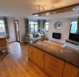 A living room with a sofa and television at Stunning 2 Bedroom Pet Friendly Lodge in Bridlington