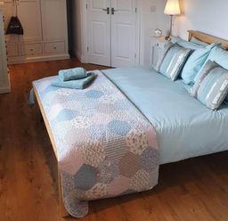 A bedroom with a bed and wardrobe at Stunning 2 Bedroom Pet Friendly Lodge in Bridlington