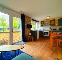 A kitchen with a dining table and chair at Painters Cottage 2Bed Chalet Free Leisure Passes Near St Ives