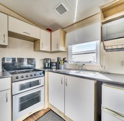 A kitchen with sink and oven at Sleeps 8 Communal Spa Access Parking in Rhyl