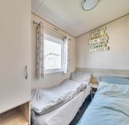 A bedroom with two beds and a window at Sleeps 8 Communal Spa Access Parking Rhyl
