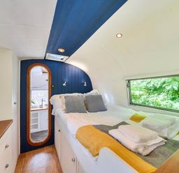 A bedroom with a bed and mirror at Sleeps 2 - Private Hot Tub - Fire Pit in St. Dogmaels near Cardigan